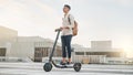 Man on scooter for travel, eco friendly transport and urban with environment and sustainability on commute to work Royalty Free Stock Photo