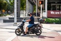 Man on a scooter wearing a mask and gloves to prevent spread of Coronavirus Covid 19