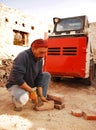 Man Scraping Bricks in Front of Bobcat Skid Loader