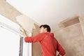 Man Scraping Paint Off Wall In Unrenovated Room Royalty Free Stock Photo