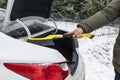 Man scraping snow from trunk car with brush. Person cleaning fresh ice after snowstorm from car in winter close up. Snow layer on Royalty Free Stock Photo