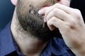 A man scratches his beard with an old beard comb Royalty Free Stock Photo