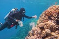 Man scuba diver cleaning plastic  from the tropical coral reef. World ocean contaminated by plastic Royalty Free Stock Photo