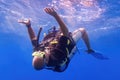 Man scuba diver kneeing on the sea surface from below - underwater skydiving