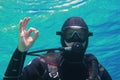 Man scuba diver underwater showing signal OK