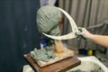 Man sculptor creates sculpt bust clay human woman sculpture. Statue craft creation workshop Royalty Free Stock Photo