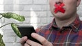 Men with a red sticky tape taped their mouths, a man with a smartphone in his hands with sticky tape taped to his lips. Royalty Free Stock Photo