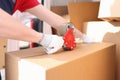 Man seals box with adhesive tape dispenser Royalty Free Stock Photo