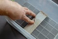 A man seals a crack in a plastic container with aluminum tape. The process of repairing a clear food container