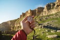 Man searching direction with a compass in his hand in the summer mountains point of view. Direction Search