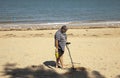 Man searching with metal detector on the beach with great expectations