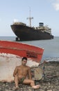 Man in the seaside near an abandoned ship