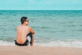 Man seated on the sand of the beach Royalty Free Stock Photo