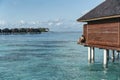 A man seated in a water villa in Maldives islands enjoying the turquoise water