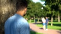 Man secretly spying loving couple walking on date outdoors, jealous ex-boyfriend Royalty Free Stock Photo