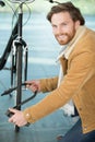 man securing bicycle with lock