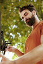 Man securing bicycle parts outdoors