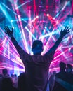 A man seen from back in a music event, dancing in neon color lights