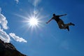 Man Jumping Off Cliff Into the Air Royalty Free Stock Photo