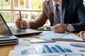 A man is seen sitting at a desk, focused on his laptop computer, A businessman seeking guidance from a financial consultant about Royalty Free Stock Photo