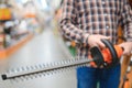 man selecting electric shears in salesroom of gardening tools shop Royalty Free Stock Photo