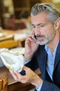 Man selecting porcelain item and calling wife