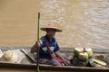 Man selling coconuts from canoe