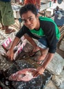 Man selling and cutting fish at a street market