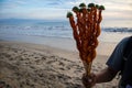 Man selling fresh seafood on the beach in the Riviera Nayarit, Mexico. His hand is holding shrimp on a stick with lime.