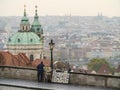 Man selling his pictures in front of Prague panorama