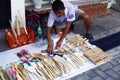 Man sells assorted wooden houseware items at a sidewalk