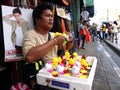 A man sells different kind of toys at a sidewalk