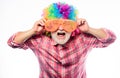 Man senior bearded cheerful person wear colorful wig and sunglasses. Elderly clown. Having fun. Funny lifestyle. Fun and