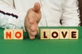 A man separates the cubes with the inscription - NO LOVE Royalty Free Stock Photo