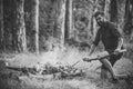 Man with serious emotion. Man hiker make fire in forest Royalty Free Stock Photo