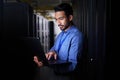 Man, server room and laptop of programming, system management and data center solution or coding at night. Business Royalty Free Stock Photo