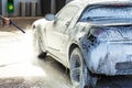 A man serves his car on a sink, applies an active foam Royalty Free Stock Photo