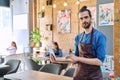 Man service worker owner in apron using laptop in restaurant cafeteria interior Royalty Free Stock Photo