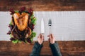 Man serving baked turkey and utensils