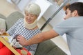 Man serving meal on tray to woman with neck injury Royalty Free Stock Photo