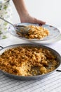 Man serving a spanish chicken paella