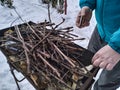 Man sets fire to wood with matches in a barbecu, grill. Camping. Royalty Free Stock Photo