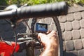 A man sets up an action camera that is fixed next to a bicycle