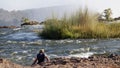 Man setting on Zambezi River side in Victoria falls , Zambia