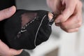 A man sews a black torn sock with white threads. Closeup.  on a white background Royalty Free Stock Photo