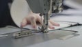 man sews clothes on sewing machine, business fashion of modern seamstress, a needle and thread are sewn making seam on