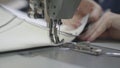 man sews clothes on sewing machine, business fashion of modern seamstress, a needle and thread are sewn making seam on