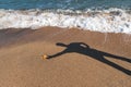 Man shadow on the hot sea sand Royalty Free Stock Photo