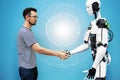 A man shakes hands with a robot close-up. engineer to create a robot. future robotics concept