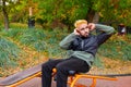 Man shakes the press on the bench at the city autumn park open air gym Royalty Free Stock Photo